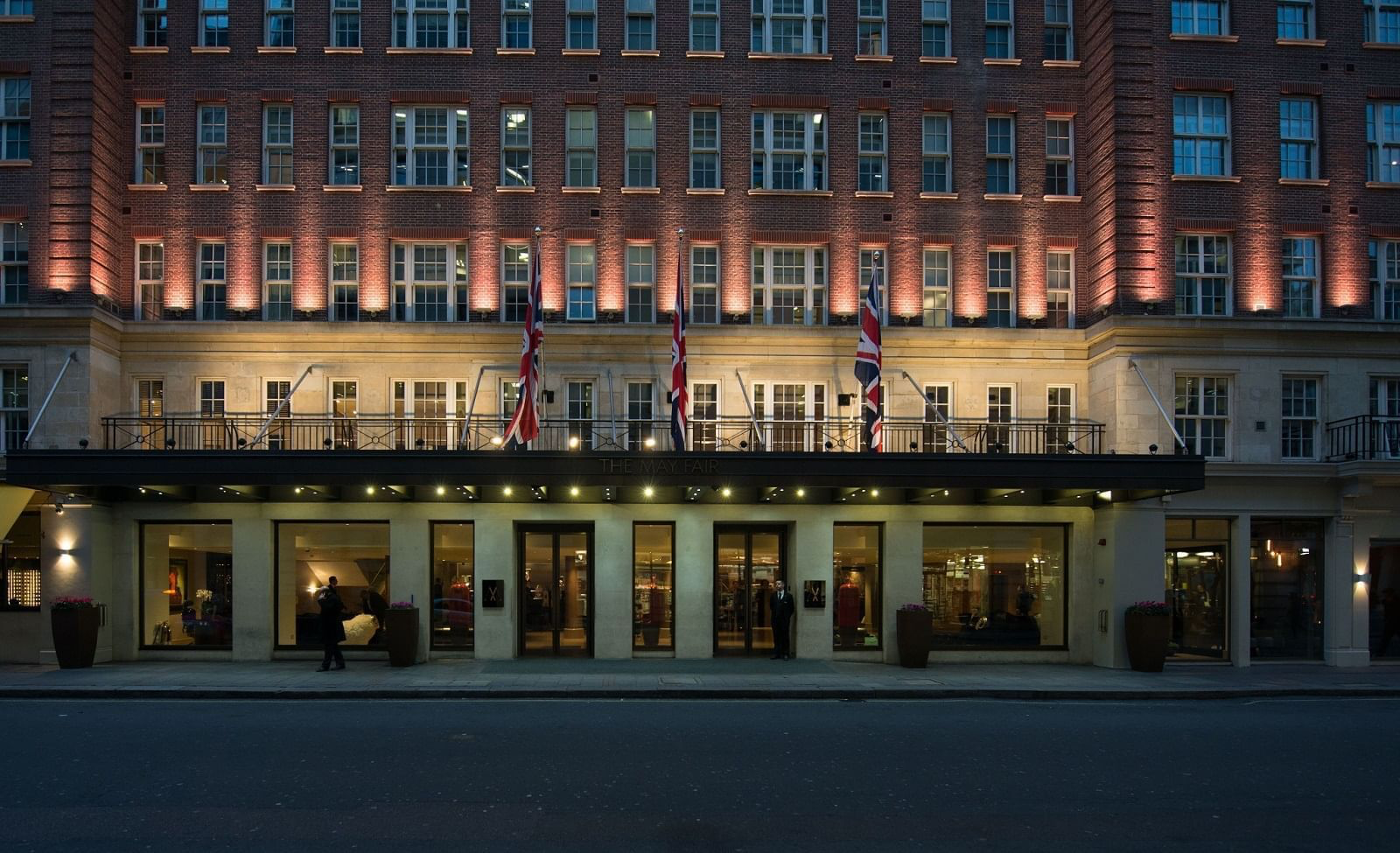 The May Fair Hotel, London, at dusk with Union Jack flags
