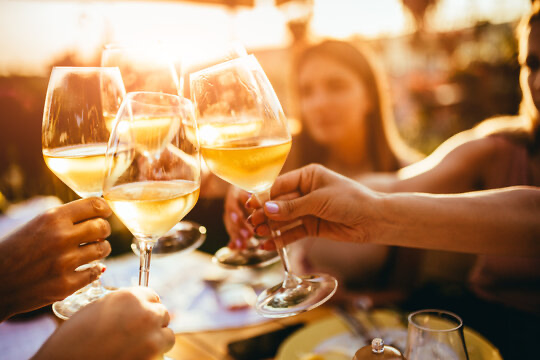 Glasses of white wine raised in a toast